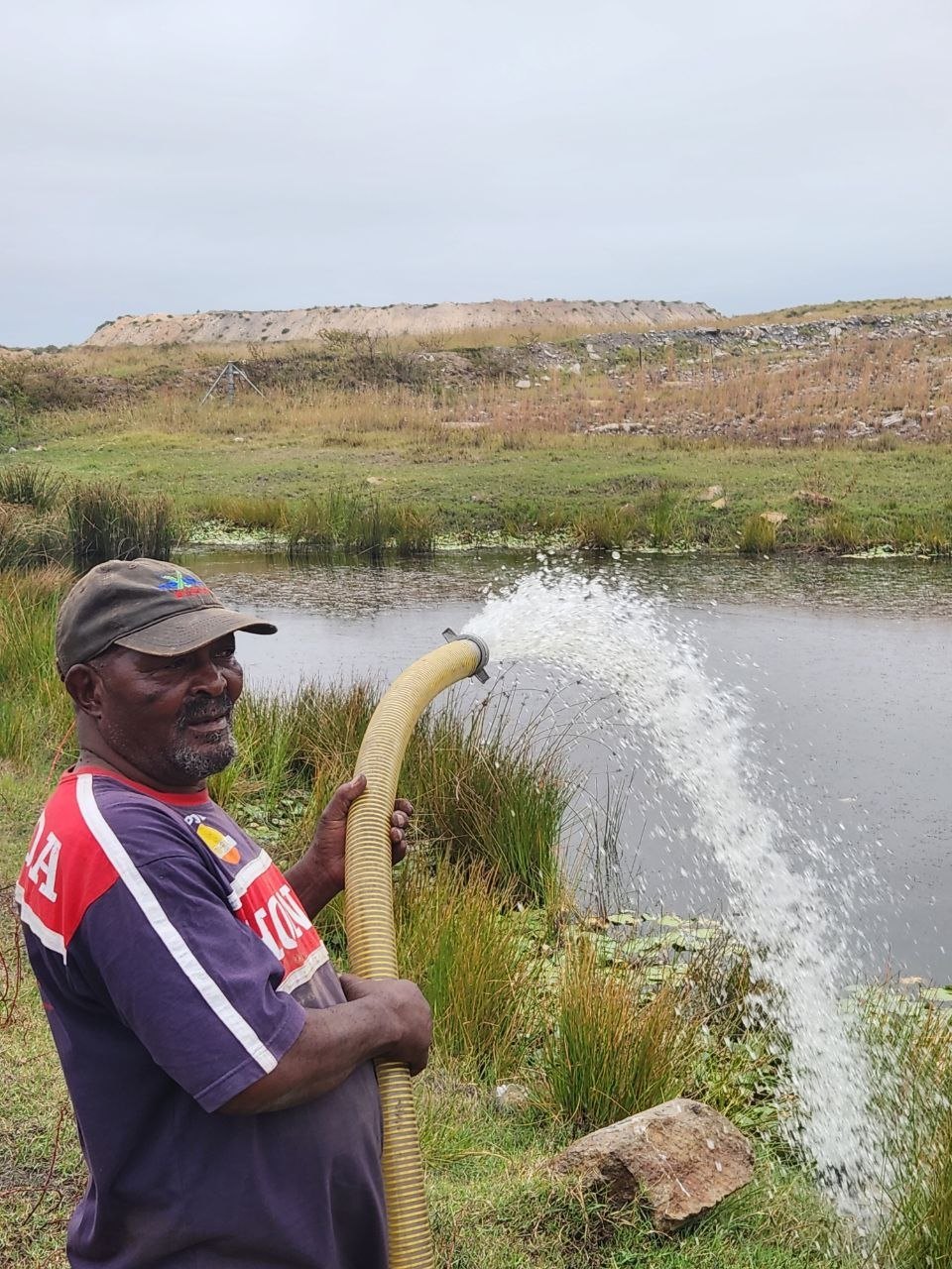 Robert Mlangeni directing water from the pump for community support and the Vulinqondo vegetable garden